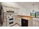 Functional kitchen featuring white appliances, wood countertops, and stylish cabinetry for all your needs at 1322 Howard Rd, Leesburg, FL 34748