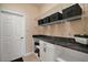 Laundry room featuring white cabinets, a countertop, and white wire shelving for storage at 13800 Wellington Ln, Grand Island, FL 32735