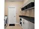 Functional laundry room with white cabinets, black countertop, and wire shelving for ample storage at 13800 Wellington Ln, Grand Island, FL 32735