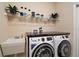 Practical laundry area with modern washer and dryer, utility sink, and shelving for storage at 13800 Wellington Ln, Grand Island, FL 32735