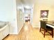 Bright hallway leads to the bedroom, featuring wood flooring and a view of the bedroom decor at 1416 Lindsey Ln, The Villages, FL 32159