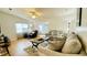 Spacious living room with wood floors, a grey sofa, and plenty of natural light from the large window at 1416 Lindsey Ln, The Villages, FL 32159