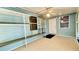 Enclosed patio featuring tile flooring, shelving, ceiling fan, and an exterior door at 1416 Lindsey Ln, The Villages, FL 32159