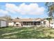 Expansive backyard featuring a screen enclosed porch, lush lawn, and mature trees at 15912 Lake Orienta Ct, Clermont, FL 34711