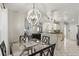 Open dining area with contemporary lighting fixture adjacent to kitchen bar seating at 15912 Lake Orienta Ct, Clermont, FL 34711