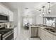 Bright kitchen featuring white cabinetry, stainless steel appliances, and modern pendant lighting at 15912 Lake Orienta Ct, Clermont, FL 34711