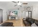 Comfortable living room with light wood floors, entertainment center and ceiling fan at 15912 Lake Orienta Ct, Clermont, FL 34711