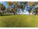 Sprawling backyard leading to the water, dotted with mature trees, perfect for outdoor enjoyment at 16011 Acorn Cir, Tavares, FL 32778