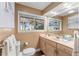 Neutral bathroom featuring a sink with cabinet, a toilet, and a window at 16011 Acorn Cir, Tavares, FL 32778