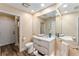 Well-lit bathroom featuring a sleek vanity with marble countertop, dual sinks, and walk-in shower at 16011 Acorn Cir, Tavares, FL 32778