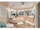 Bright bathroom boasts a corner tub, wood floors, double windows, and a vanity with sink at 16011 Acorn Cir, Tavares, FL 32778