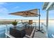 Dockside seating area with umbrella, table, chairs, and stylish decor on a wooden pier at 16011 Acorn Cir, Tavares, FL 32778