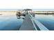 Long wooden dock on a serene lake, leading to boat lift and lounging area at 16011 Acorn Cir, Tavares, FL 32778