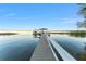 Tranquil lake view featuring a long wooden dock, gazebo, and abundant natural beauty at 16011 Acorn Cir, Tavares, FL 32778