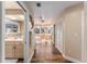 Hallway view leading to a bright bathroom, featuring wood floors and ample closet space at 16011 Acorn Cir, Tavares, FL 32778