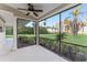 Relaxing screened lanai featuring ceiling fan and serene views of landscaped yard and waterfront at 16011 Acorn Cir, Tavares, FL 32778
