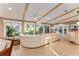 Bright living area boasting beamed ceilings and walls of windows showcasing water views at 16011 Acorn Cir, Tavares, FL 32778