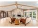 Bright living room with stone fireplace, beamed ceilings, and neutral-toned furniture at 16011 Acorn Cir, Tavares, FL 32778
