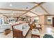 Open-concept living space with beamed ceilings seamlessly connects living, dining, and kitchen areas at 16011 Acorn Cir, Tavares, FL 32778