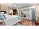 Spacious bedroom featuring wood floors, a ceiling fan, and sliding glass doors to an outdoor area at 16011 Acorn Cir, Tavares, FL 32778