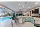 An airy outdoor kitchen seamlessly connects to the pool area, complete with bar seating and modern appliances at 16011 Acorn Cir, Tavares, FL 32778