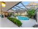 Lush greenery surrounds a screened pool and patio, creating a private and tranquil outdoor retreat at 16011 Acorn Cir, Tavares, FL 32778