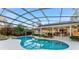 A serene pool under a screened enclosure, surrounded by lush greenery and offering an outdoor living space at 16011 Acorn Cir, Tavares, FL 32778