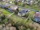 Aerial shot of a home with a pool, patio, and fenced yard, nestled in a neighborhood with mature trees and well-kept lawns at 16620 Caravaggio Loop, Montverde, FL 34756