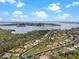 An aerial view shows the property's location near a lake, surrounded by lush greenery and other residential homes at 16620 Caravaggio Loop, Montverde, FL 34756