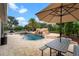 Resort-style pool with rock features and a waterfall, complemented by outdoor seating and mature landscaping at 16620 Caravaggio Loop, Montverde, FL 34756