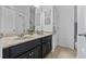 Bathroom with a double sink vanity, marble countertops, dark cabinets, and a shower with tile surround at 16620 Caravaggio Loop, Montverde, FL 34756