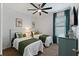 Well-lit bedroom featuring two twin beds, sunflower art, a ceiling fan, and stylish green accents at 16620 Caravaggio Loop, Montverde, FL 34756