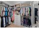 Bright walk-in closet with custom shelving, drawers, hanging racks, and carpeted floors for optimal storage and organization at 16620 Caravaggio Loop, Montverde, FL 34756