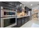 Modern kitchen with stainless steel appliances, custom cabinetry, a tile backsplash, and a walk-in pantry at 16620 Caravaggio Loop, Montverde, FL 34756