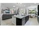 An open concept view of the kitchen, dining room, and living room with a large kitchen island with seating at 16620 Caravaggio Loop, Montverde, FL 34756