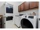 Laundry room with modern washer and dryer, with extra storage in adjacent room at 16620 Caravaggio Loop, Montverde, FL 34756