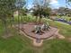 Community playground featuring swings, slides, and climbing structures, surrounded by mature trees and grassy areas at 16620 Caravaggio Loop, Montverde, FL 34756