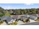 Aerial view of a home showcasing its roof, landscaping, and neighborhood setting near a pond at 16801 Se 74 Soulliere Ave, The Villages, FL 32162