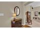 Warm entryway with a wood cabinet, mirror, decorative lamp, and views of the living area at 16801 Se 74 Soulliere Ave, The Villages, FL 32162