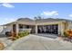 Charming home featuring a beige exterior, well-kept landscaping, screened in porch, and oversized garage at 16801 Se 74 Soulliere Ave, The Villages, FL 32162