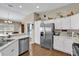 Contemporary kitchen with stainless steel refrigerator, white cabinets, and granite countertops at 16801 Se 74 Soulliere Ave, The Villages, FL 32162