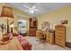 Comfortable office featuring a vaulted ceiling, ceiling fan, wooden desk, and a cozy red sofa at 16801 Se 74 Soulliere Ave, The Villages, FL 32162