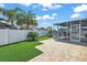 Landscaped backyard featuring artificial turf, lanai, and a white privacy fence at 1781 Kingfisher Ct, The Villages, FL 32162