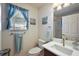 Bright bathroom with a window, a white countertop sink, and blue accents at 1781 Kingfisher Ct, The Villages, FL 32162