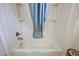 Clean bathtub featuring a showerhead, a blue curtain, and white tiling at 1781 Kingfisher Ct, The Villages, FL 32162