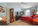 Cozy bedroom with a tall clock, a comfortable red bed, and light blue walls at 1781 Kingfisher Ct, The Villages, FL 32162