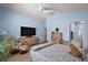 Light-filled bedroom featuring a ceiling fan, blue walls, and laminate flooring at 1781 Kingfisher Ct, The Villages, FL 32162