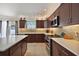 A spacious kitchen featuring dark wood cabinets, stainless steel appliances, and a white countertop island at 1781 Kingfisher Ct, The Villages, FL 32162