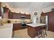 Contemporary kitchen featuring dark wood cabinetry, stainless steel appliances, and a white countertop island at 1781 Kingfisher Ct, The Villages, FL 32162