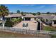 Landscaped backyard featuring brick pavers, lounge chairs, and a white picket fence at 1802 Dalton Dr, The Villages, FL 32162